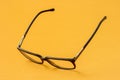 Eyeglasses with black frame on yellow background Royalty Free Stock Photo