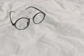 Eyeglasses with black plastic temple on white bed sheet Royalty Free Stock Photo