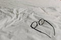 Eyeglasses with black plastic temple on white bed sheet Royalty Free Stock Photo