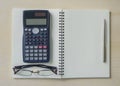 Eyeglasses,calculator and silver pen on spiral notebook