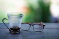 Eyeglasses, Coffee glasses cup with coffee stains stuck on them, then after drinking it on wooden table in bokeh blurred green Royalty Free Stock Photo