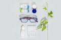 Eyeglasses, containers with contact lenses and eye drops Royalty Free Stock Photo