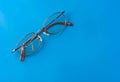 Eyeglasses with cracked lens on shiny blue background Royalty Free Stock Photo