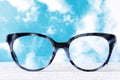 Eyeglasses Glasses with Bifocals and Black Blue Frame smudged agaist a blue and cloudy sky