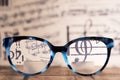 Eyeglasses Glasses with Bifocals and Black blue Frame smudged agaist musical note sheet. Blurry Vision Concept