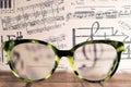 Eyeglasses Glasses with Bifocals and Black blue Frame smudged agaist musical note sheet. Blurry Vision Concept