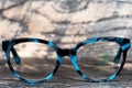 Eyeglasses Glasses with Bifocals and Black Blue Frame smudged Fashion Vintage Style on Wood Desk Background, Rustic Still Life