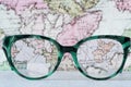 Eyeglasses Glasses with Bifocals and Black Blue Frame smudged Fashion Vintage Style on Wood Desk with world map background