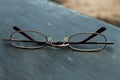 Eyeglasses on the glossy metal tile of the cutting platform.