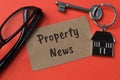 Eyeglasses, key and toy house with text PROPERTY NEWS