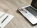 Eyeglasses on laptop computer and a black pencil on a notebook Royalty Free Stock Photo
