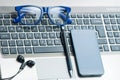 Eyeglasses on laptop keyboard with smartphone, pencil and headphones office concept Royalty Free Stock Photo