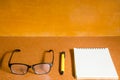 Eyeglasses, notebook and pen on wooden table Royalty Free Stock Photo