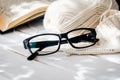 Eyeglasses, open book, Cup of tea and Knitting threads Royalty Free Stock Photo