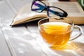 Eyeglasses, open book, Cup of tea and Knitting threads Royalty Free Stock Photo
