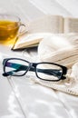 eyeglasses, open book, Cup of tea and Knitting threads Royalty Free Stock Photo