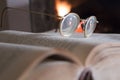 Eyeglasses, open book and fireplace Royalty Free Stock Photo