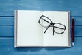 Eyeglasses on opened notebook with pen Royalty Free Stock Photo