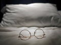 An eyeglasses optics on white linen bed, low light night time, shortsighted, nearsighted, farsighted, eyewear business products,