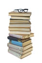 Eyeglasses on the top of the stack of books on the white background Royalty Free Stock Photo