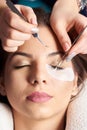 Eyelash Extension Procedure. Close-up hands beautician with tweezers in hands Royalty Free Stock Photo