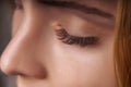 Eyelash Extension Procedure. Woman Eye with Long Eyelashes. Close up, selective focus.