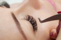 Eyelash removal procedure close up. Beautiful Woman with long lashes in a beauty salon.