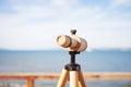 eyepiece of a wooden telescope against the ocean view
