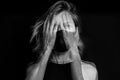 Dramatic black and white artistic portrait of blonde young woman hiding her face. Royalty Free Stock Photo