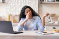 Eyes fatigue concept. Freelancer lady tired after working on laptop in kitchen interior, woman taking off glasses Royalty Free Stock Photo