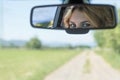 The eyes of the young driver woman are reflected in the rearview mirror. Royalty Free Stock Photo