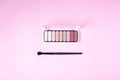 Eyeshadow palette and make up brush on pink background with copyspace top view Royalty Free Stock Photo