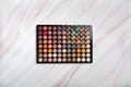 Eyeshadow palette on marble texture with natural pattern. Flat lay. Top view