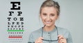 Eyesight check. Woman in glasses on the background of eye test chart Royalty Free Stock Photo