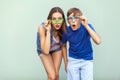 Eyewear concept. WOW faces. Young sister and brother with freckles on their faces, wearing trendy glasses, posing over light green Royalty Free Stock Photo