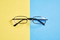 Eyewear placed on a pastel yellow and blue background divides the halves Royalty Free Stock Photo