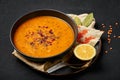 Ezogelin Soup in black bowl on dark slate table top. Turkish cuisine traditional dish with red lentils, bulgur and rice