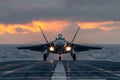 F-22 Raptor jet making a vibrant touchdown on an aircraft carrier at sunset Royalty Free Stock Photo