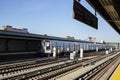 F subway train approaching elevated station in Brooklyn, New York. Train tracks on the outdoor platform