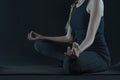 F`it woman practicing yoga pose stratching . sport workout fitness. yoga mat and leggins on a dark black background