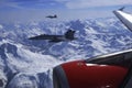 FA-18 military jets from Swiss Airforce escorting civil airplaine in the swiss alps
