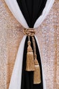 A fabric background of gilt and curtains with black and white fabric. Small elegant details