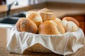 fabric basket with assorted bread rolls on a kitchen counter Royalty Free Stock Photo