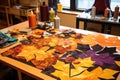 fabric cutouts for a fall-themed quilt on a sewing table