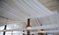 Fabric drape on the restaurant ceiling. Bright interior, lighted lantern. The decor for the wedding party