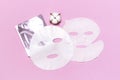 Fabric face mask, cotton flowers on pink background. Concept of natural cosmetics, face care, spa, face cream, women`s beauty