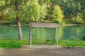 Shade overhang alongside river with foliage on banks