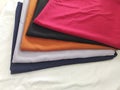 Fabric piles colored red black orange gray and dark blue