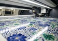 Digital fabric printing machine in action, showcasing vibrant floral patterns on roll-to-roll fabric, emphasizing precision and Royalty Free Stock Photo
