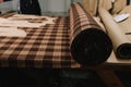 Fabric roll rests on table for marking and measuring, ready for cutting and garment production. Royalty Free Stock Photo